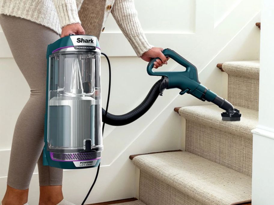 Woman cleaning stairs with a shark powerclean vacuum