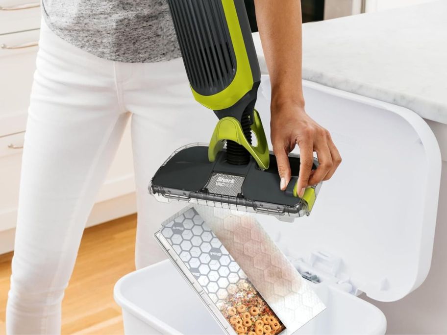 A woman emptying a Shark VACMOP 