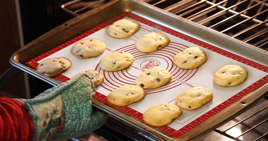 cookies on a baking mat and tray being put into the oven