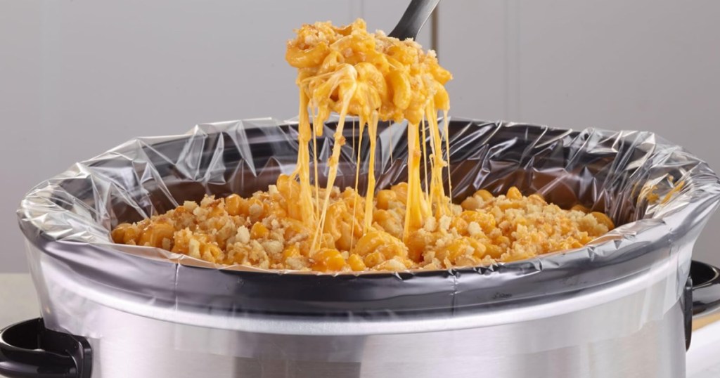 Plastic liner inside slow cooker filled with cheesy macaroni