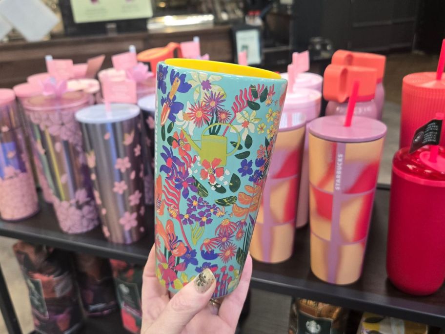 hand holding starbucks tumbler in store