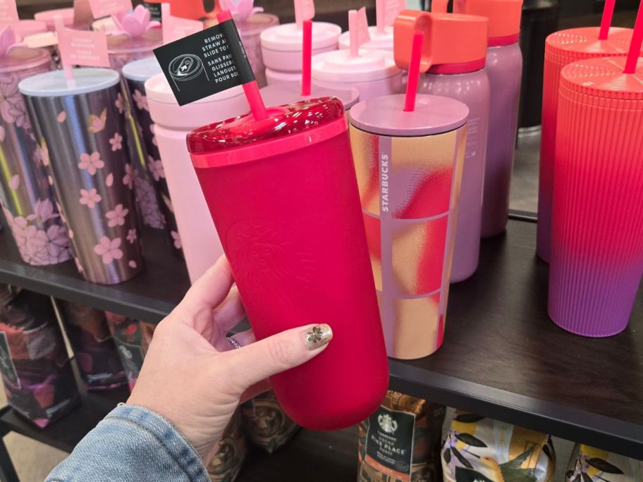 hand holding starbucks pink tumbler in store