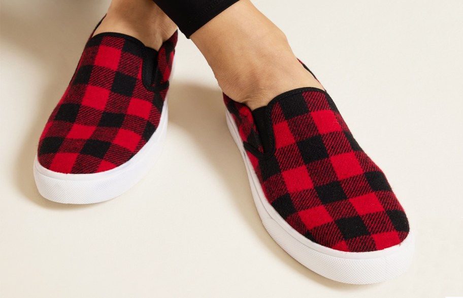 woman wearing pair of red and black buffalo paid sneakers