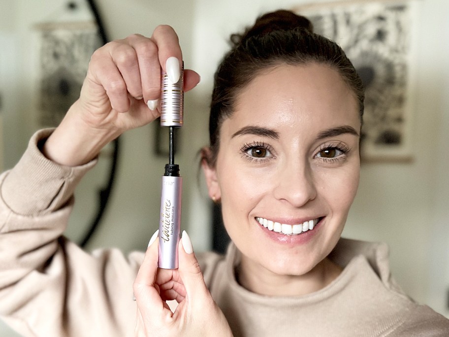 woman holding up a tube of Tarte Tubing Mascara