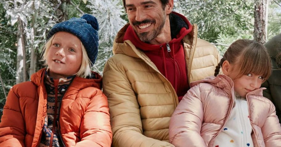 man wearing walmart outerwear with two children