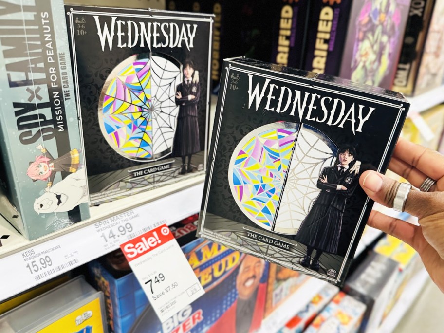 hand holding up Wednesday The Card Game in front of store shelf