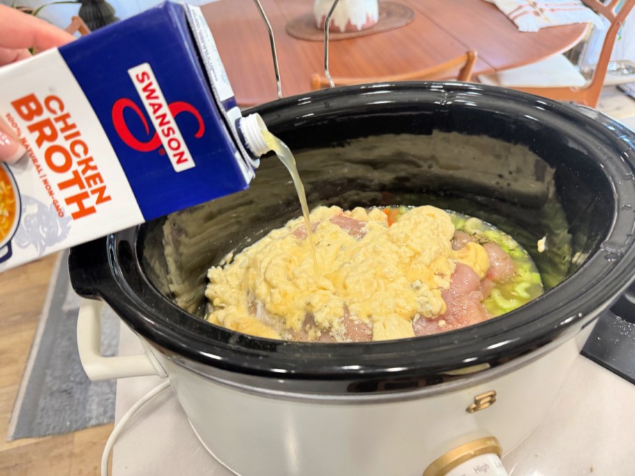 adding chicken broth to slow cooker dumpling soup 