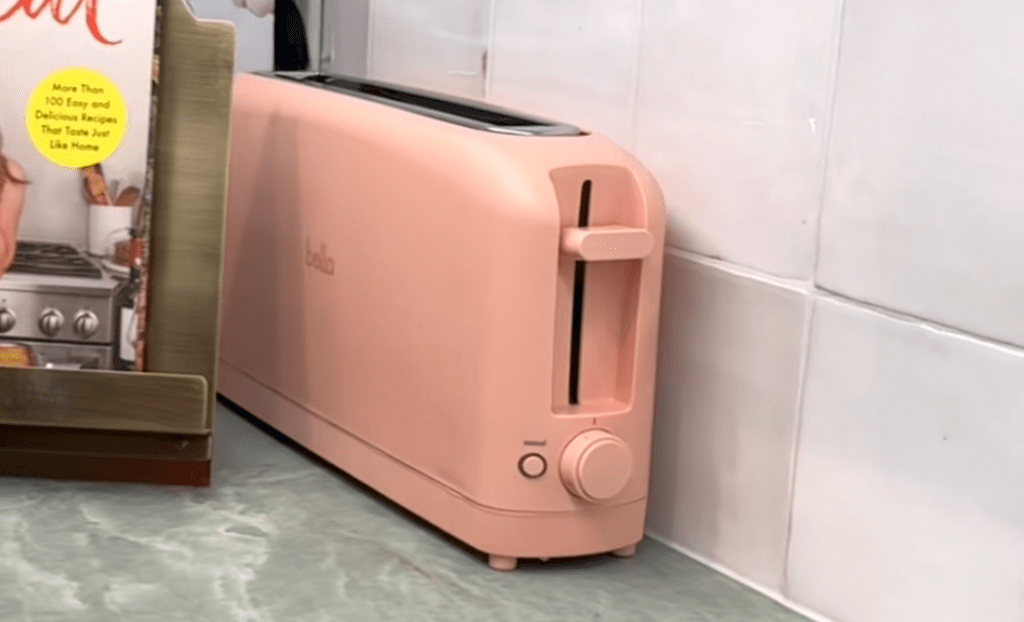 pink slim toaster on green countertop