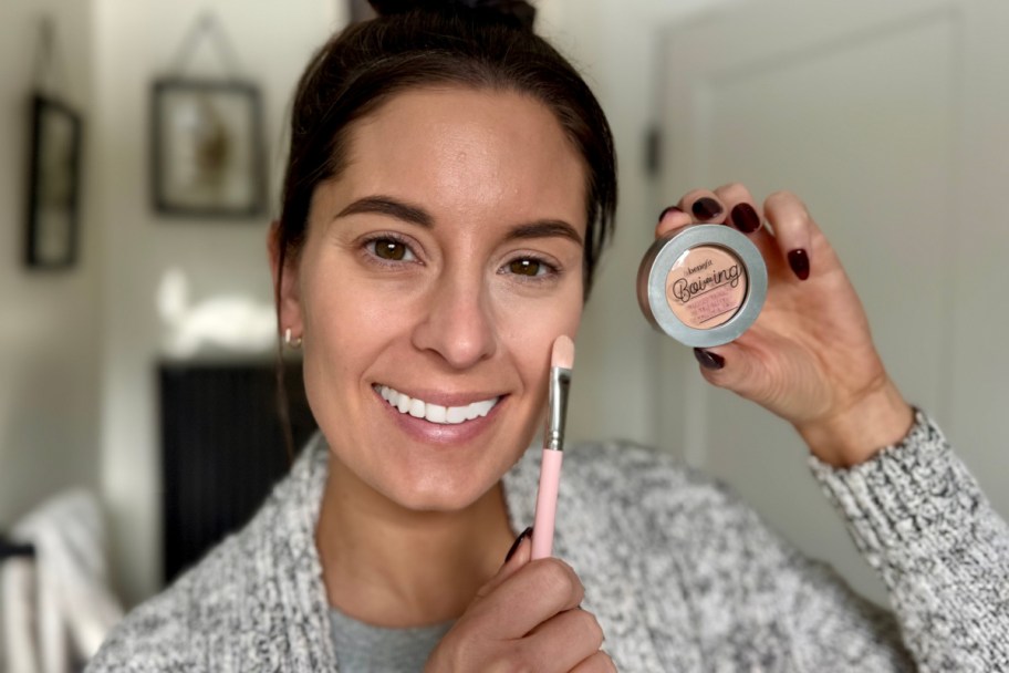 woman holding concealer near face