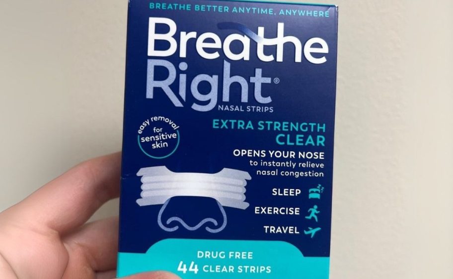 a mans hand holding a box of breathe right nasal strips