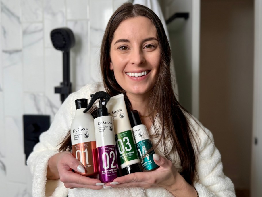 woman holding four haircare items