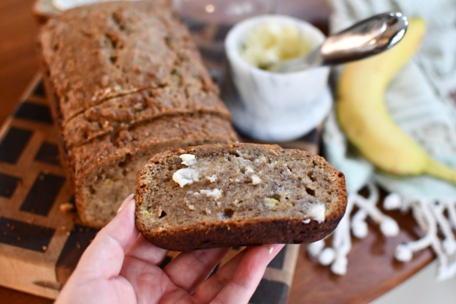 holding sourdough banana bread with butter