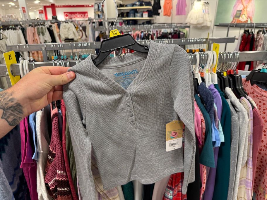 a girl's cardigan in hand in store