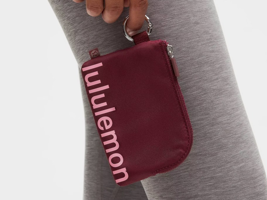 woman holding a red lululemon card pouch