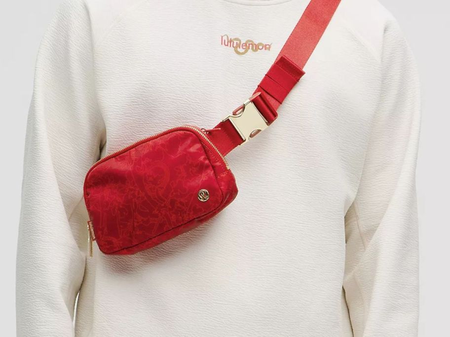 A person wearing a red lululemon belt bag