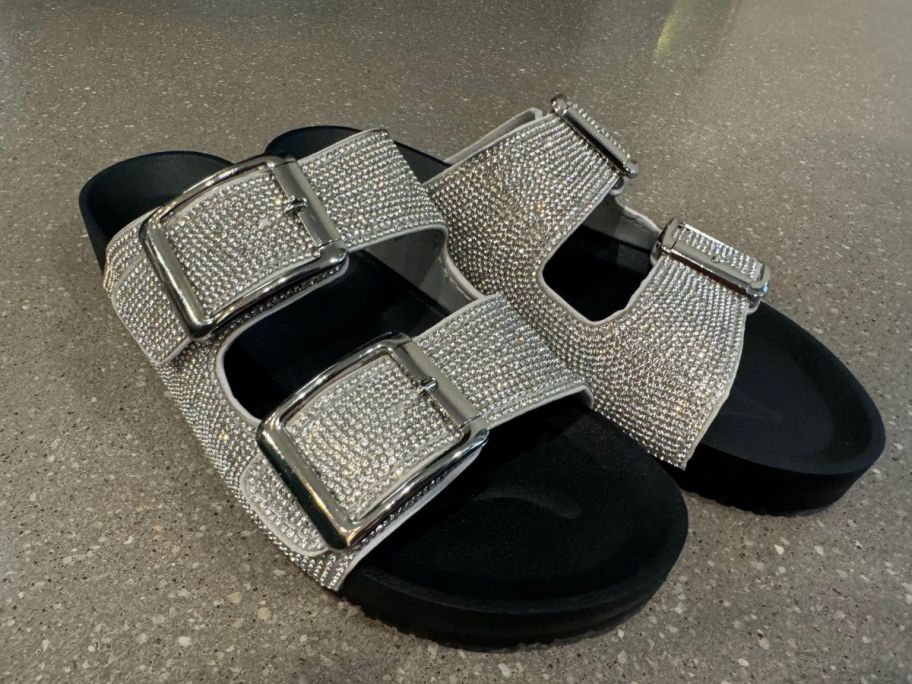 black and silver Madden NYC Women's Embellished Footbed Sandals on floor