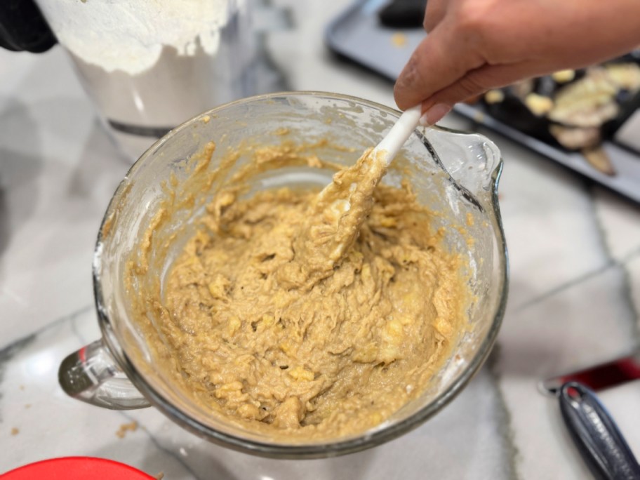 mixing banana bread batter in a glass batter bowl 