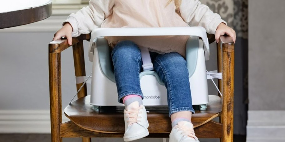 toddler sitting in green and white booster seat