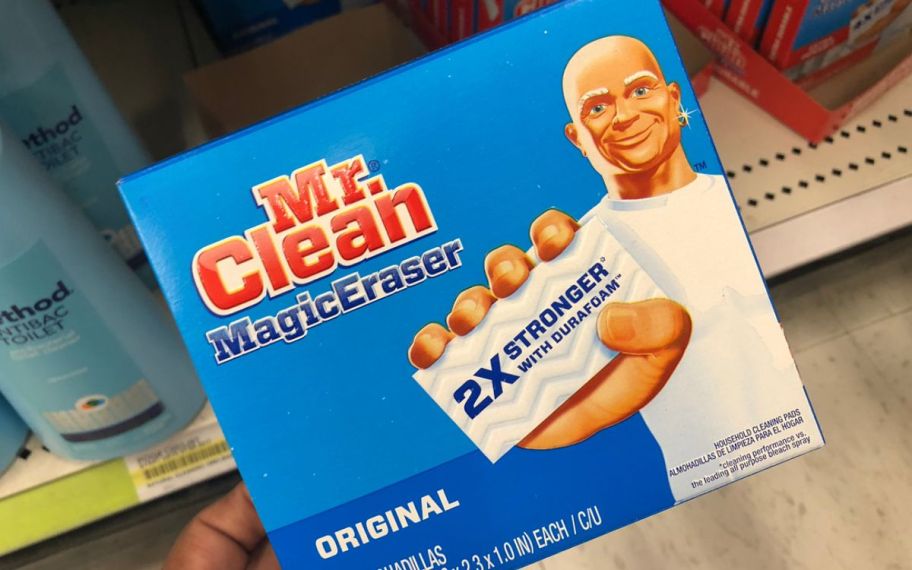 a womans hand holding a box of mr. clean magic erasers