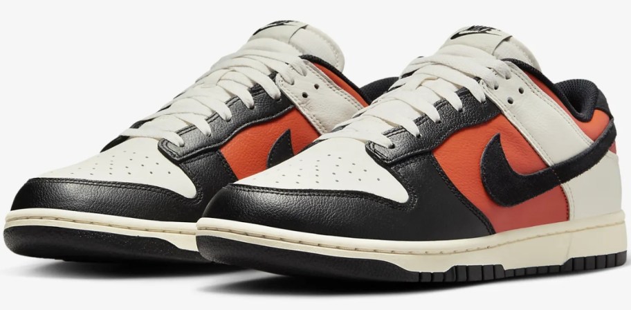 a pair of white, black, and orange men's Nike Dunk sneakers