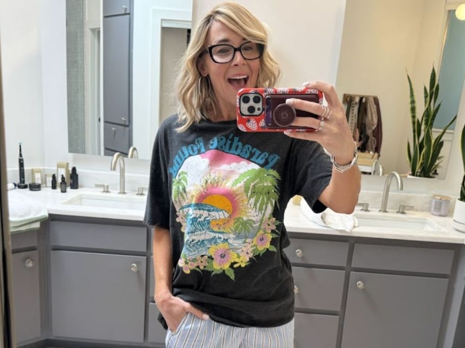 a woman in a graphic tee taking a selfie