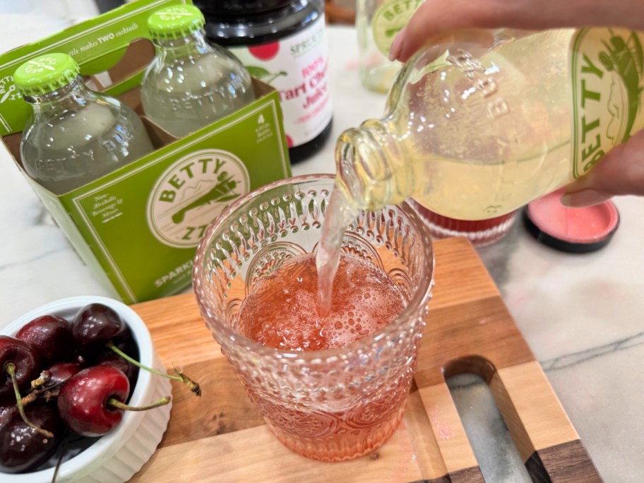 pouring lemon lime sparkling water into a cup 