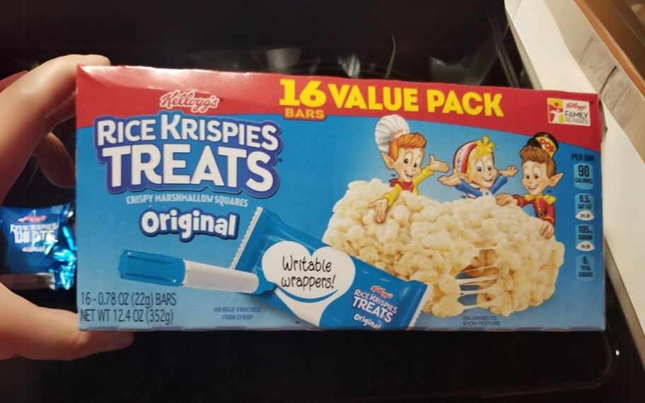 a hand holding a box of rice krispies treats