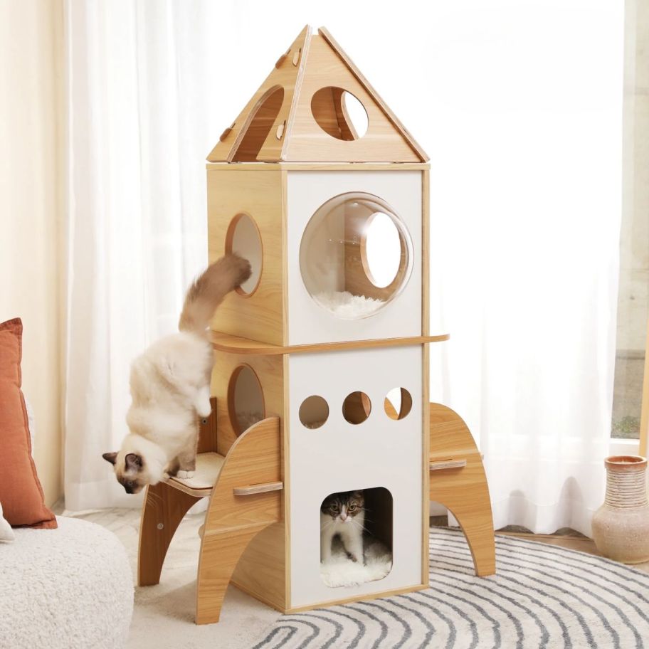 rocket themed cat tree with 2 cats in it