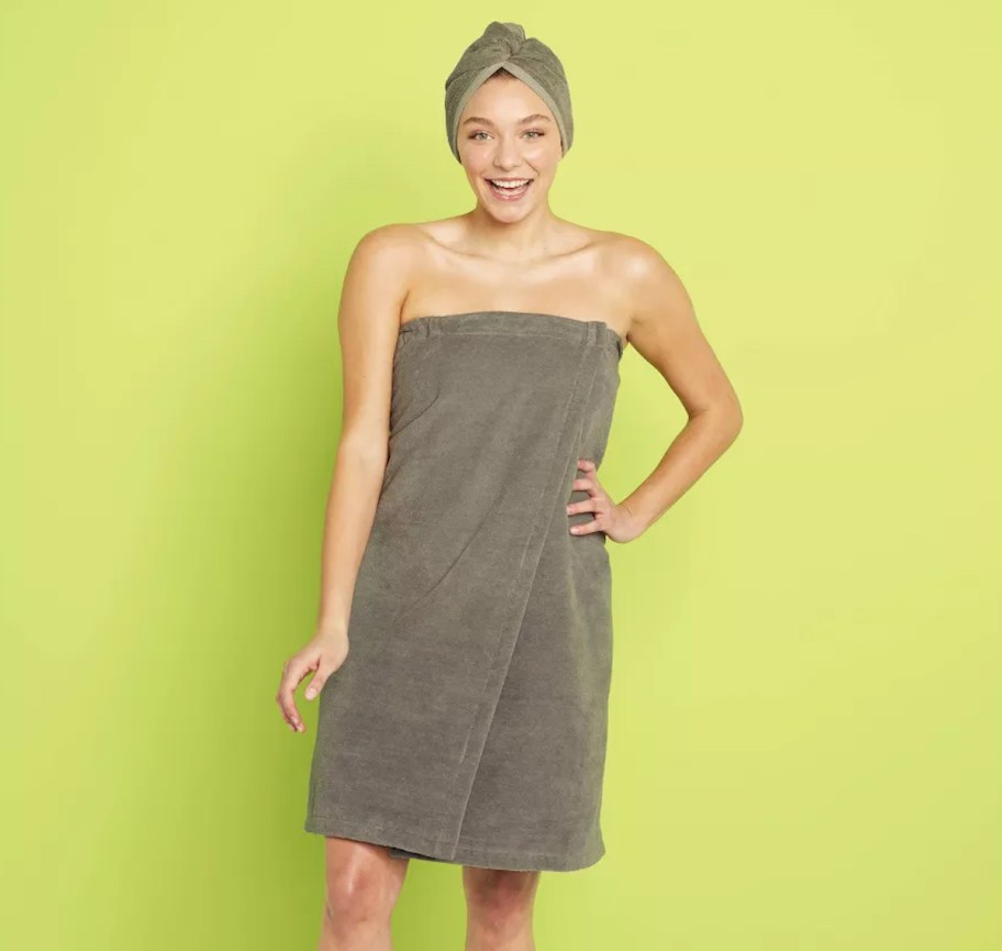 woman wrapped in gray towel with green background