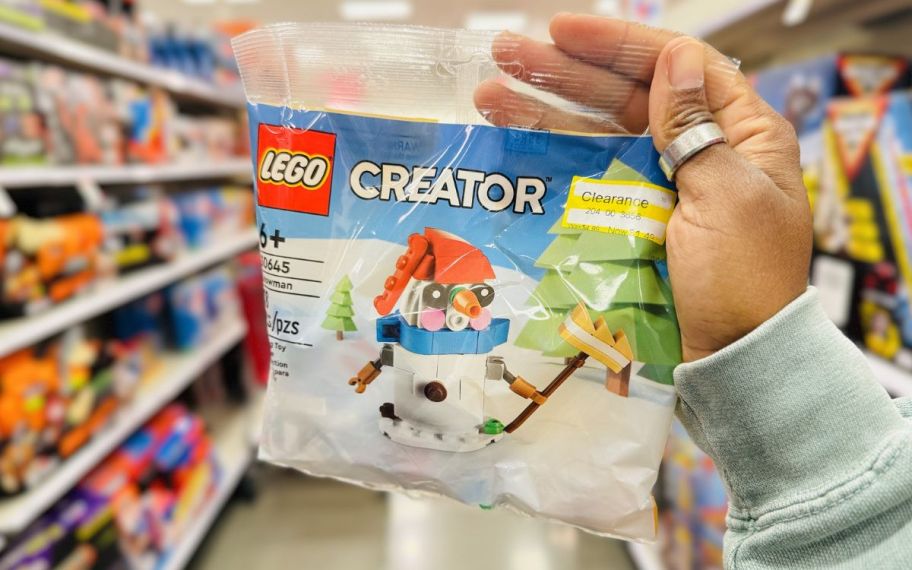 a womans hand holding a LEGO creator snowman