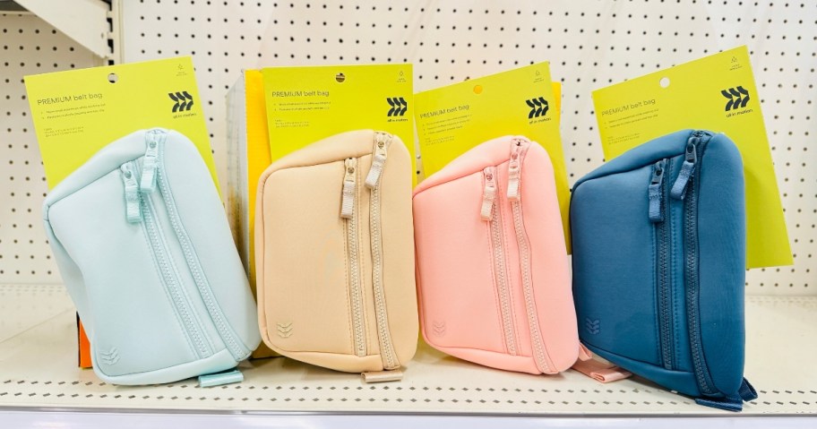 four different color belt bags on a store shelf