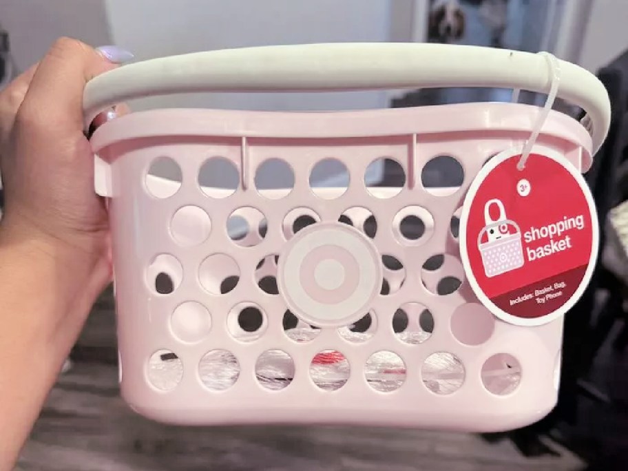 woman holding up a pink target toy basket 