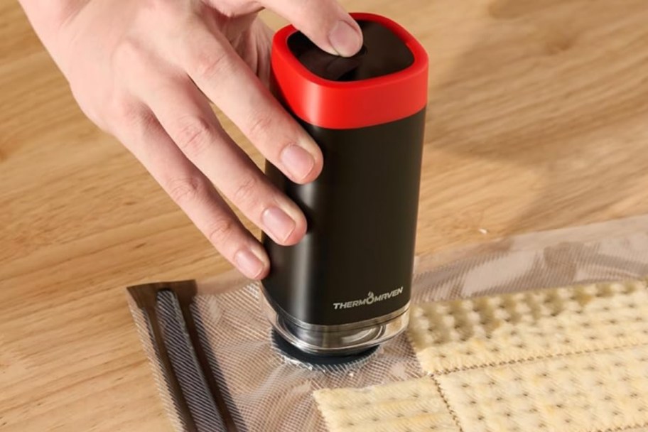 hand holding vacuum sealer on bag