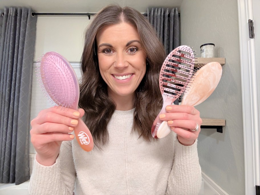 woman holding up 3 wet brushes