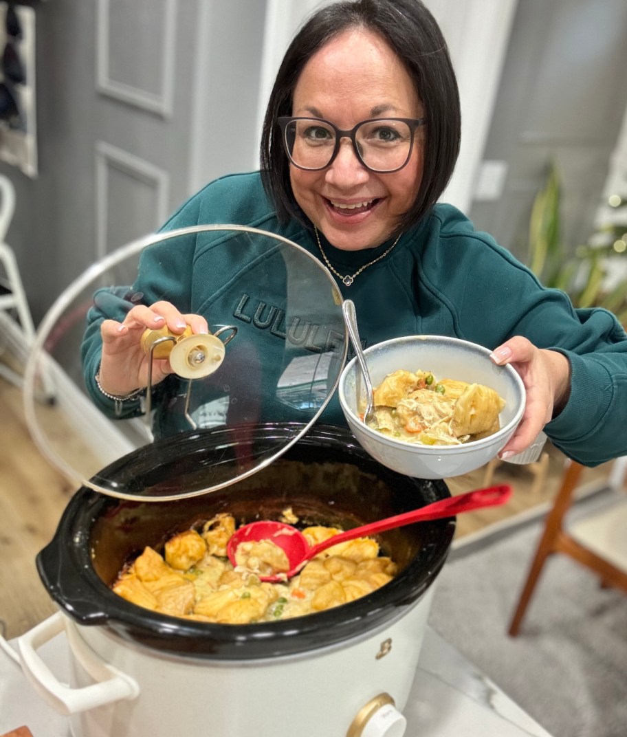 woman holding a bowl of chicken and dumplings soup 