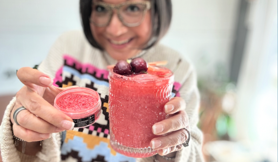 woman holding glitter mocktail