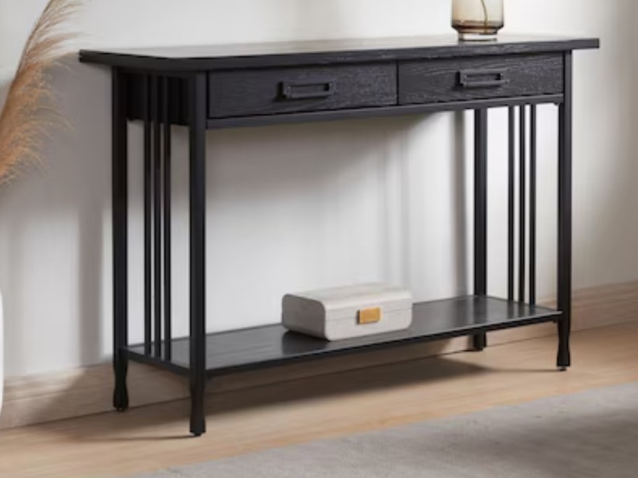 a dark brown wood console table in a hallway