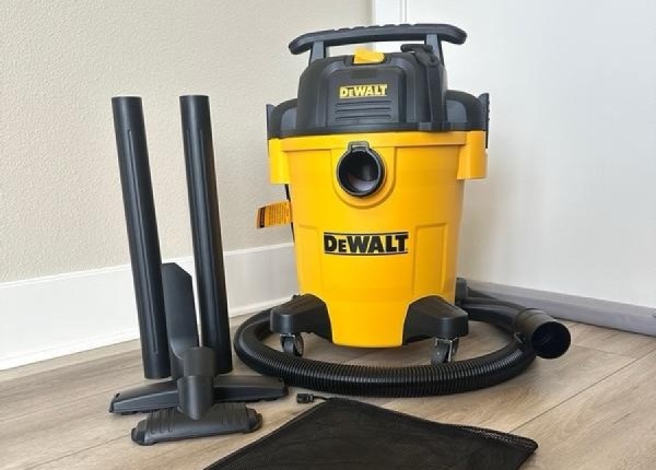 DEWALT 6-Gallon 4-HP Corded Wet/Dry Shop Vacuum with Accessories sitting in corner of room