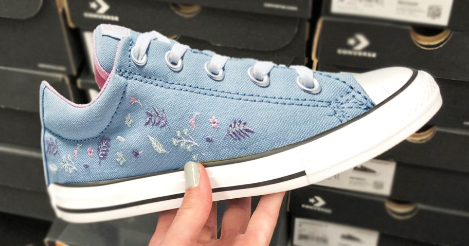 hand holding up a blue embroidered converse sneaker