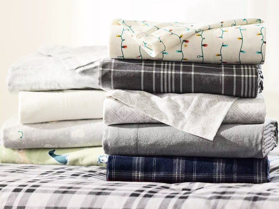 stack of folded flannel sheets in various colors and prints