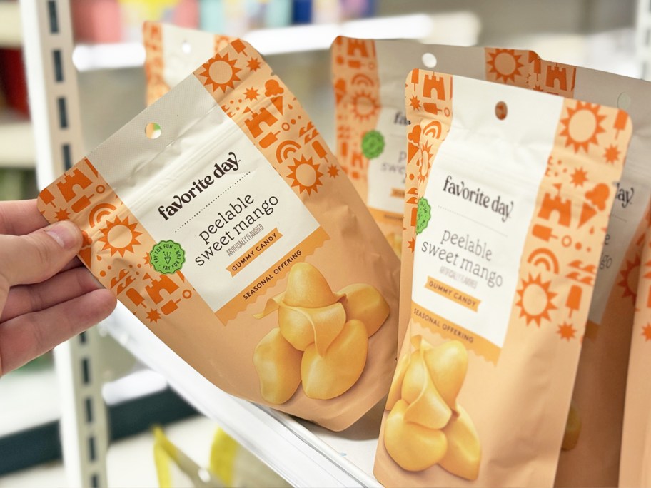 grabbing a bag of Favorite Day Peelable Sweet Mango Gummy Candy from store shelf