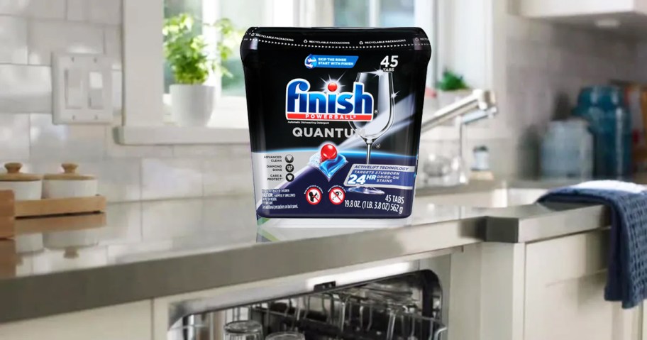 container of Finish Quantum Dishwasher Pods on kitchen counter above dishwasher