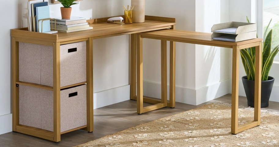 light brown l-shaped desk with tan fabric storage cube bins in a home office