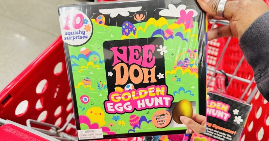 hand holding a colorful box with a Nee Doh Golden Egg Hunt in it