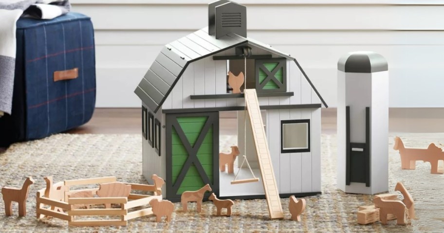 a wooden toy black and white barn with silo and farm animals