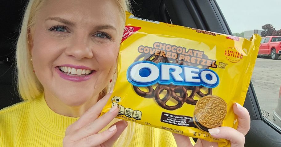 A woman holding a bag of Oreo cookies 