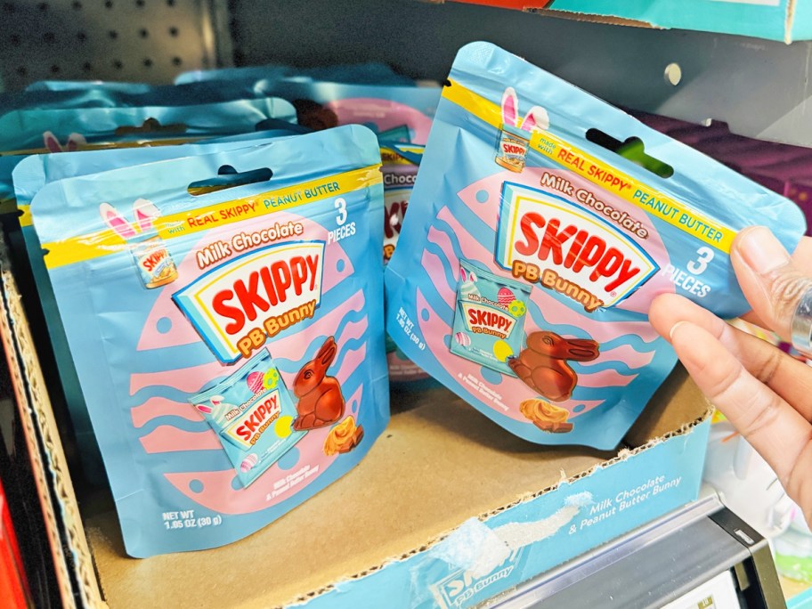 hand grabbing SKIPPY Peanut Butter Bunny bag from store shelf