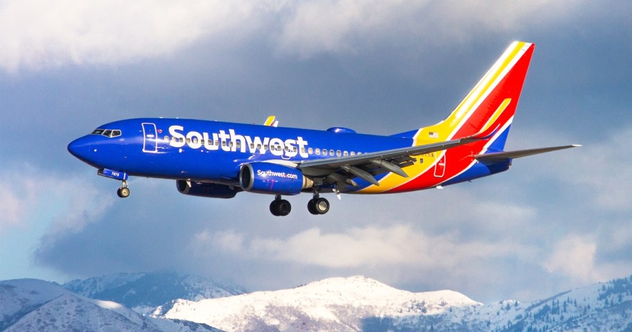 Southwest Airlines plane landing with snowy mountains in background