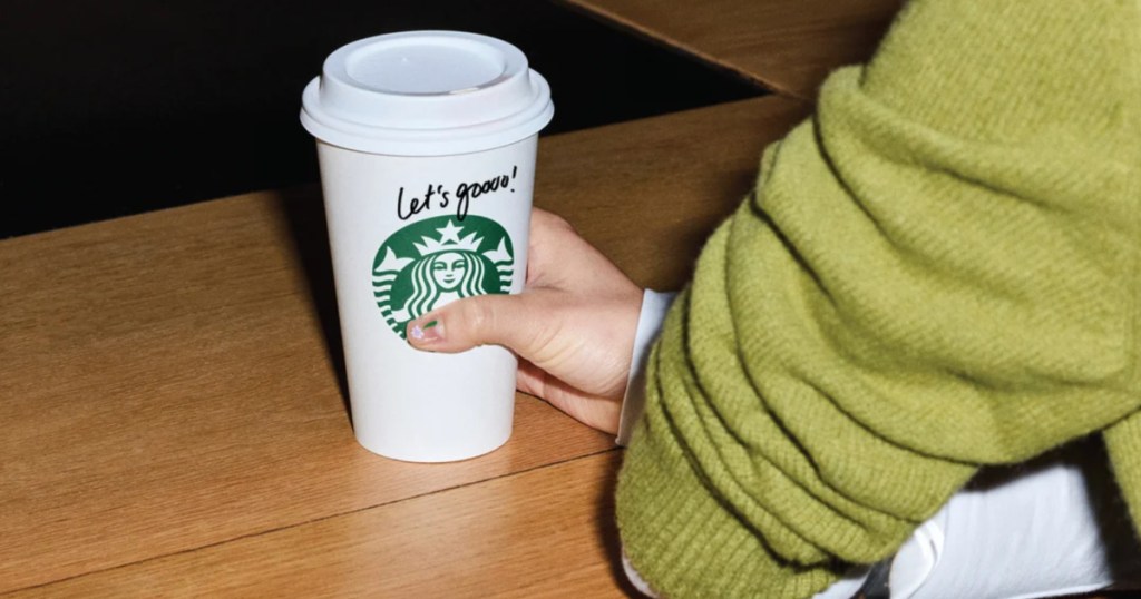 Starbucks, coffee cup on counter with let's go written on it