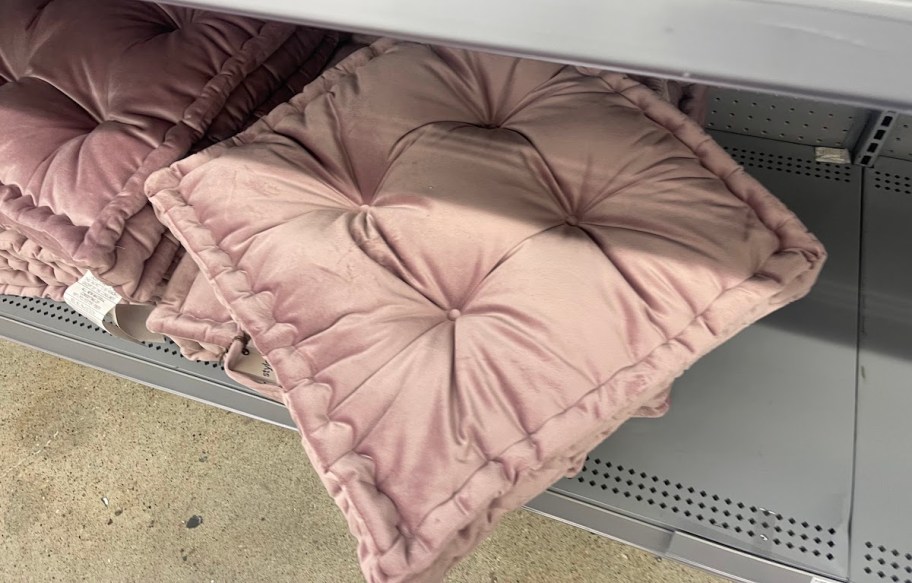 purple pink floor pillows on bottom store shelf